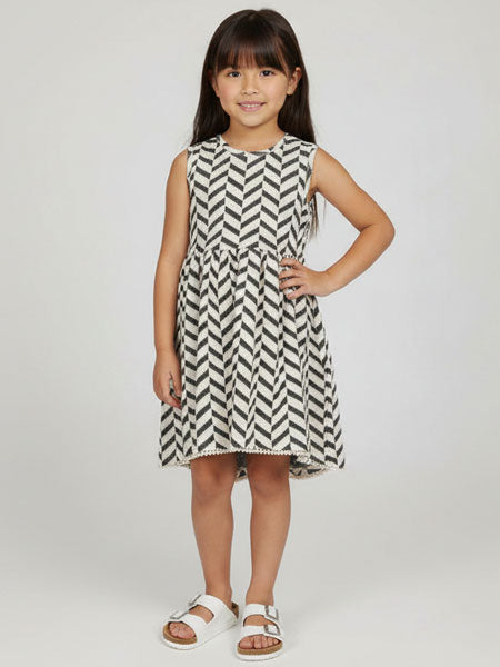 Young girl wearing a black and white patterned dress on a white background