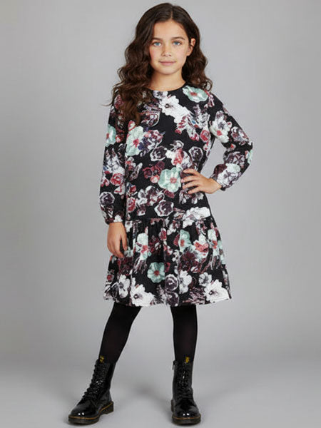 Girl wearing a floral dress with long sleeves on a gray background