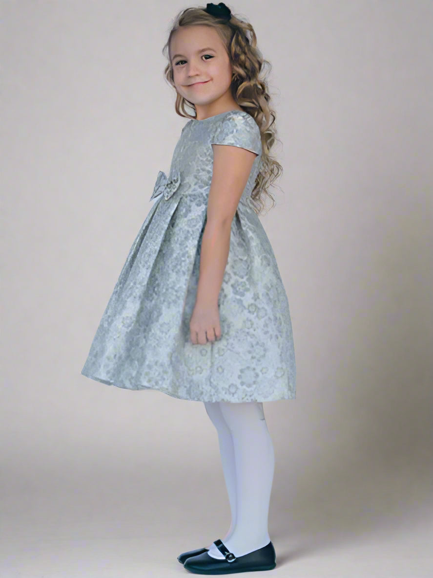 Young girl wearing a floral dress on a gray background