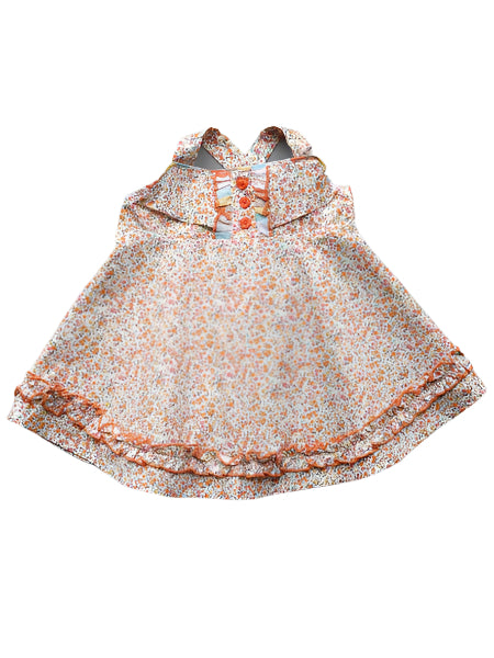 Floral sleeveless baby dress with buttons.