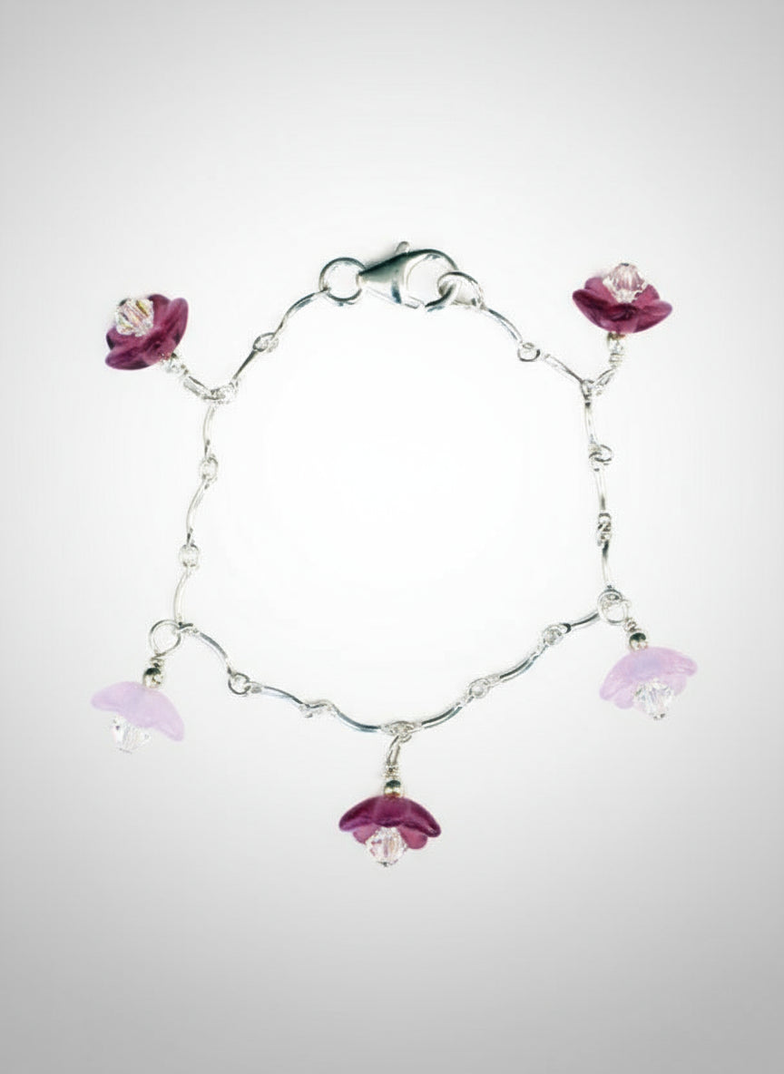 A sterling silver bracelet with cranberry and pink Czech glass flowers, and Swarovski crystals, featuring a lobster-claw clasp.