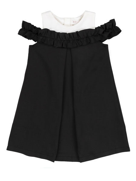 Girls black party dress, cold shoulder style. White accent fabric at neckline.
