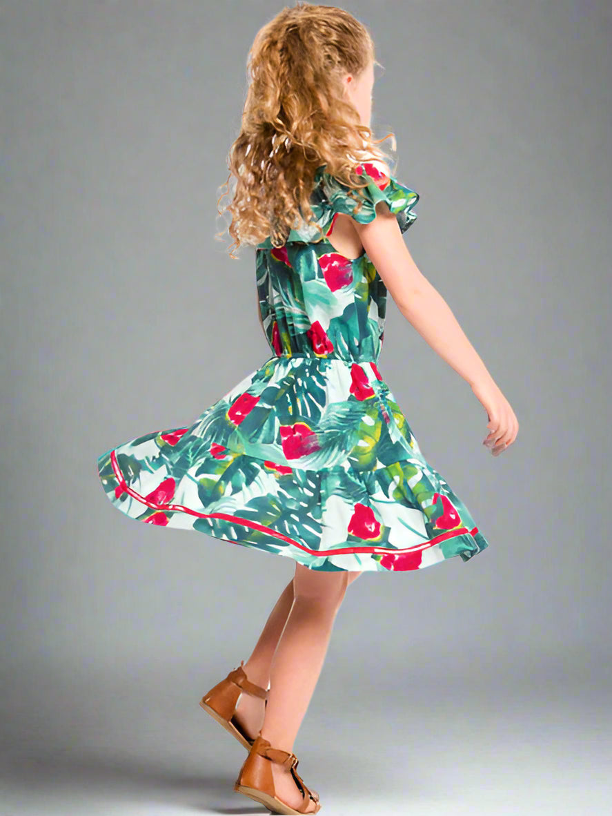 Girl wearing the watermelon print girls sundress by Deux par Deux. Cold shoulder ruffle neckline with thin straps. Gathered waist with full skirt.