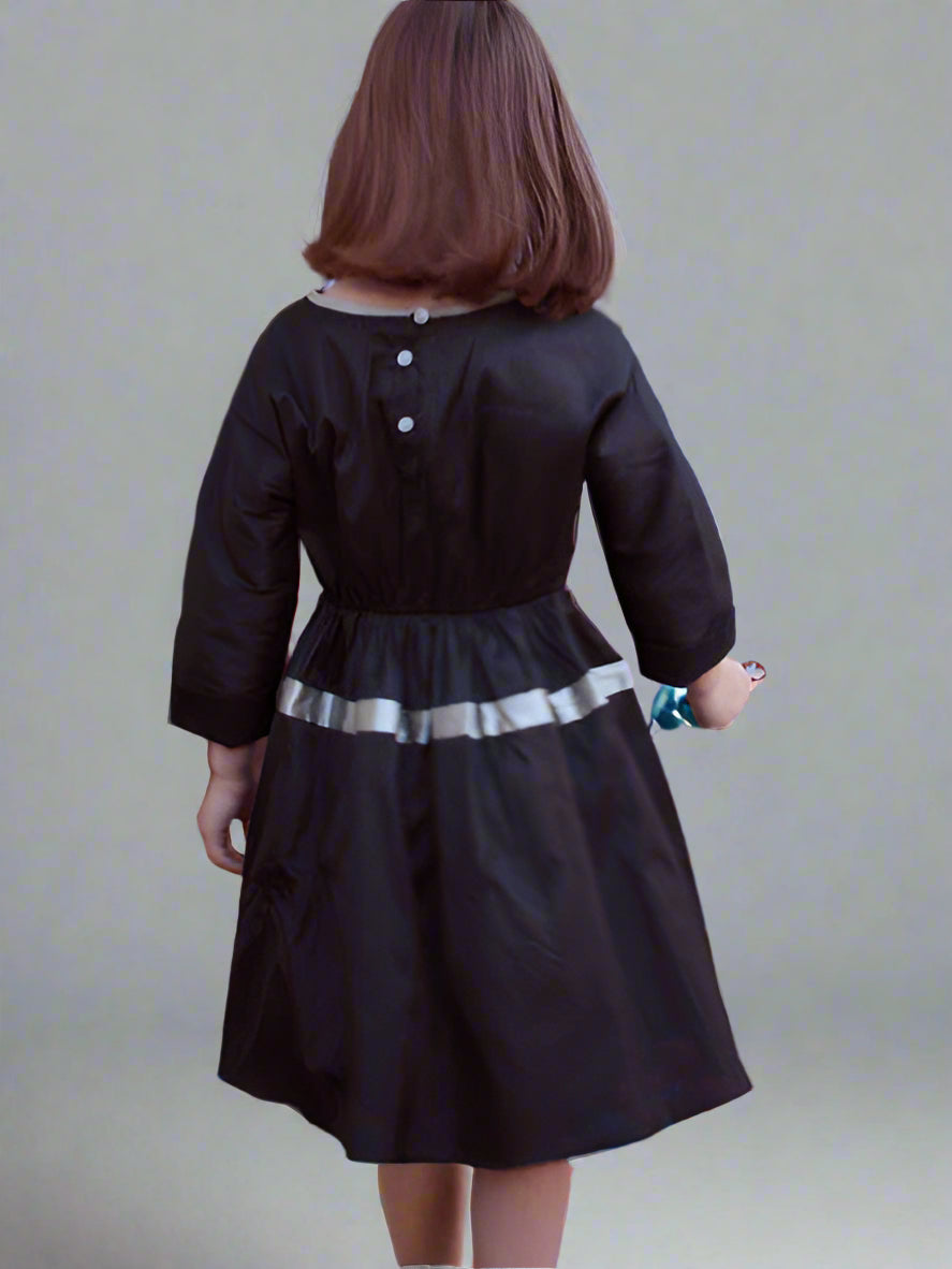 Black shantung silk taffeta dress for girls. Cuffed sleeve, elastic waist, with full skirt. Back view.