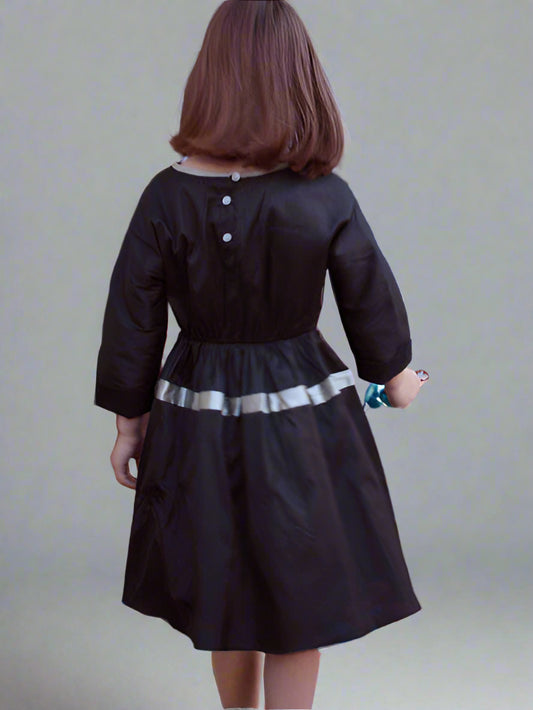 Black shantung silk taffeta dress for girls. Cuffed sleeve, elastic waist, with full skirt. Back view.