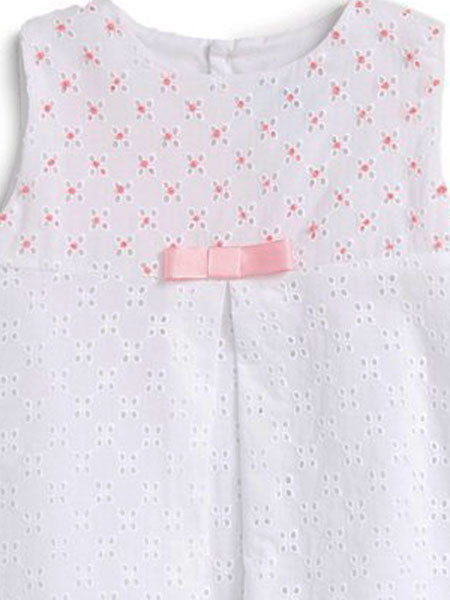 Detail image of A-line white eyelet dress with center pleat for baby girls. Pink accents on upper bodice, small pink bow.