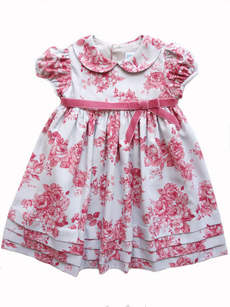 Rose print on grey baby girls party dress by Luli & Me. Puffed cap sleeves, Peter Pan collar, rose velvet ribbon at empire waist.