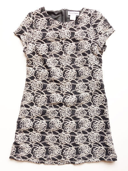 Girls' dress with ecru and black color scheme featuring a floral embroidered pattern on a black background.