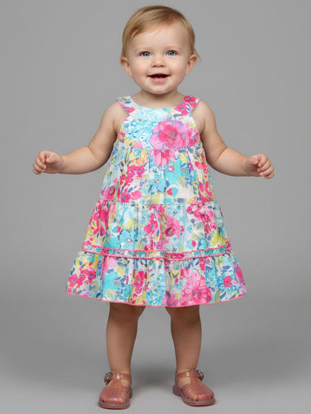 Child wearing a colorful floral dress on a gray background