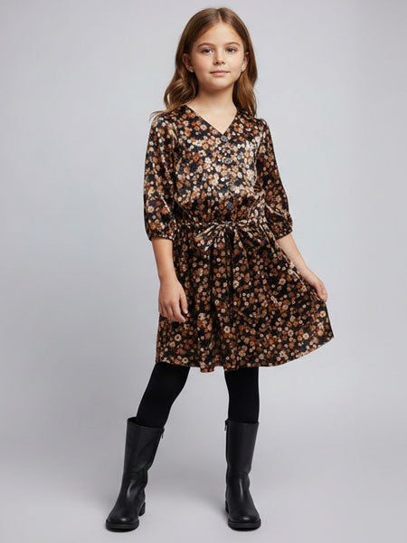 Young girl wearing a floral dress with black boots on a plain background