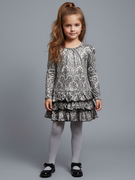 Young girl wearing a damask patterned dress on a gray background