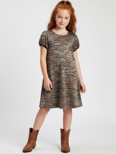 Young girl wearing a patterned dress and brown boots on a white background