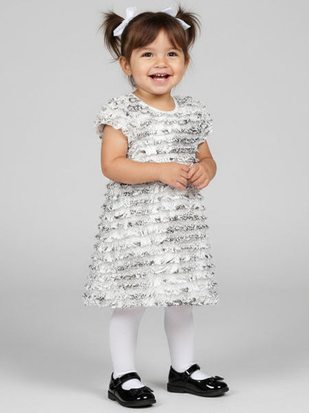 Child wearing a sequined dress with a plain background