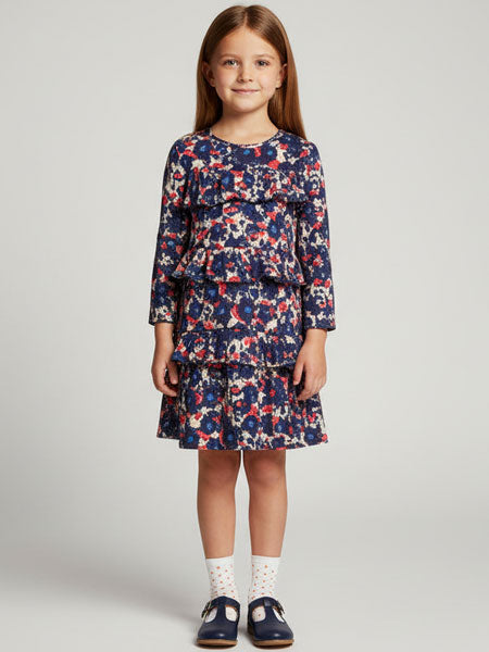 Young girl wearing a floral dress on a plain background