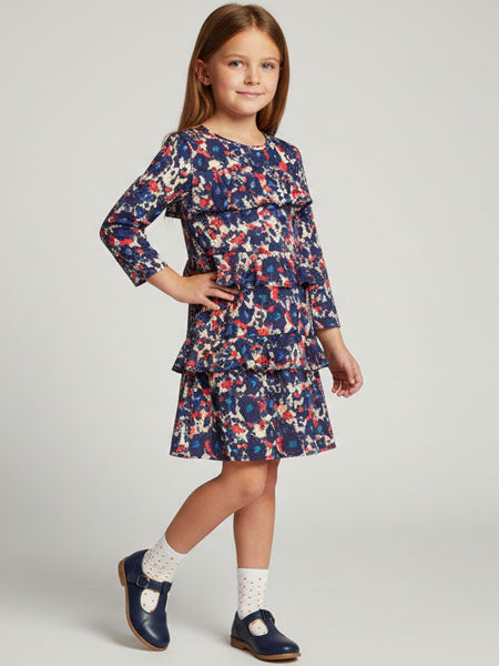 Young girl wearing a floral dress on a plain background