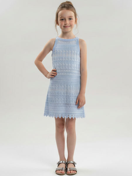Young girl wearing a light blue dress with lace details on a white background