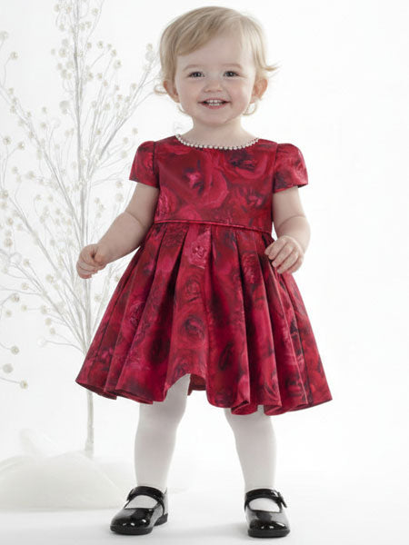 Baby girl wearing a red floral dress with white background