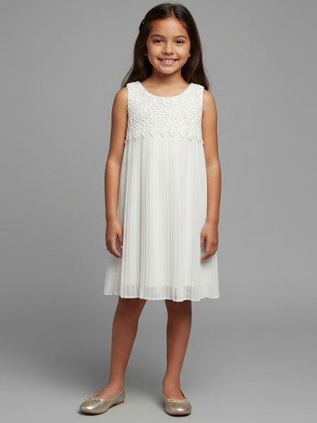 Young girl wearing a white dress against a gray background