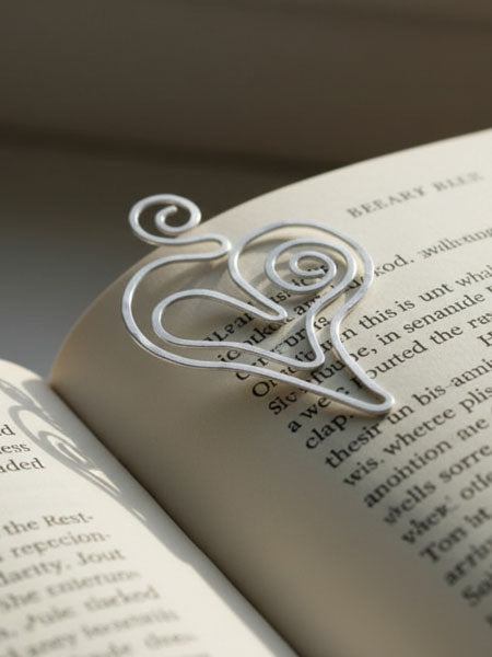 Silver heart-shaped bookmark on an open book