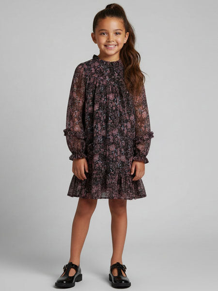 Young girl wearing a floral dress against a plain background