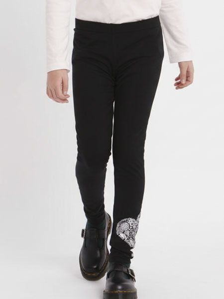 Person wearing black leggings with a silver heart on a white background