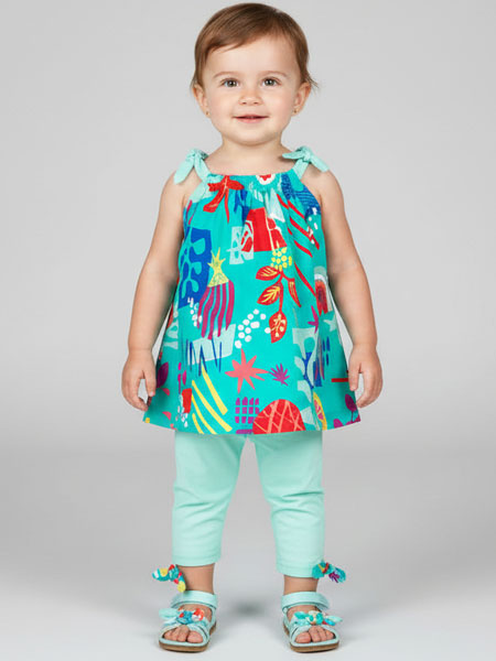 Child wearing a colorful outfit with a turquoise background