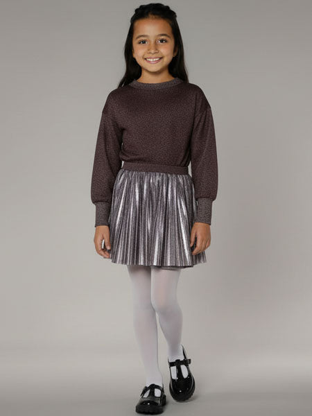 Young girl wearing a brown sweater and silver skirt on a gray background
