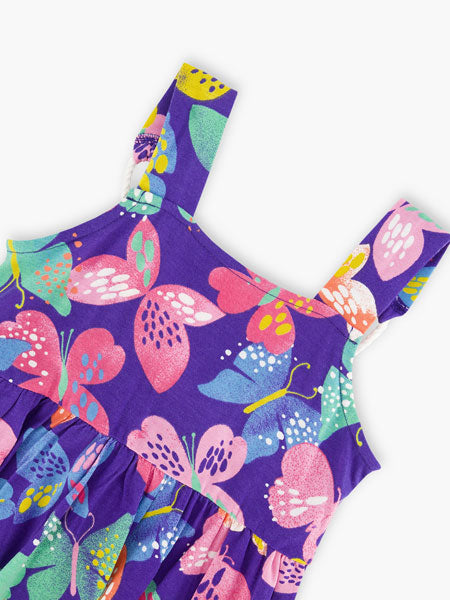 Detail of fabric Deux Par Deux sleeveless girls sundress. Printed colorful butterfly pattern on blue.