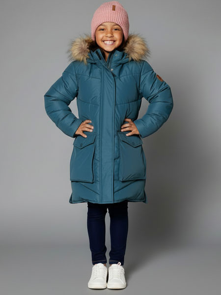 Child wearing a blue winter coat with fur hood and pink beanie on a gray background