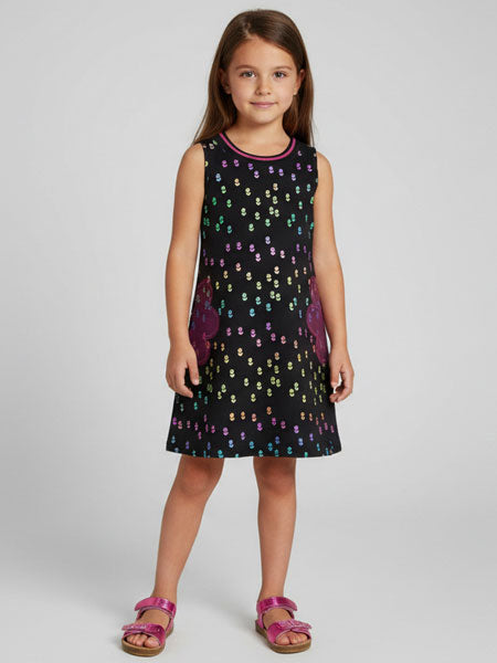 Young girl wearing a black dress with colorful patterns on a white background