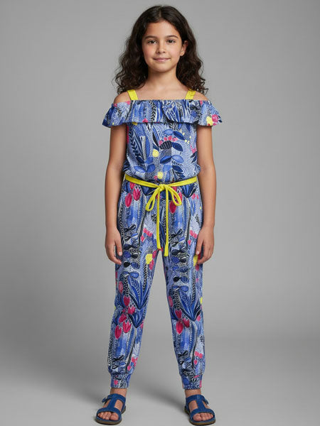 Young girl wearing a colorful off-shoulder top and pants on a gray background