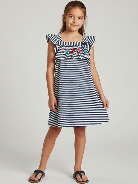Girl wearing a navy and white striped dress with floral embroidery on a plain background