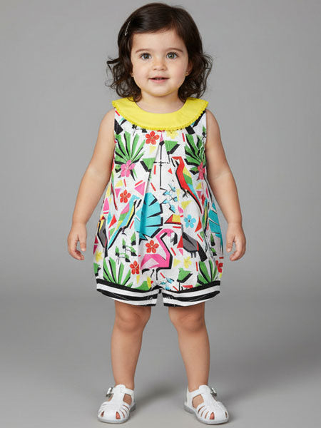 Child wearing a parrot print one piece summer romper with floral and bird pattern on a gray background