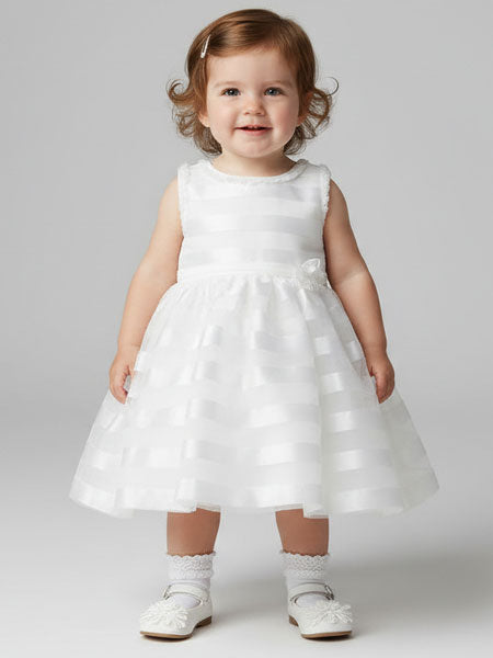 Child wearing a white dress on a plain background