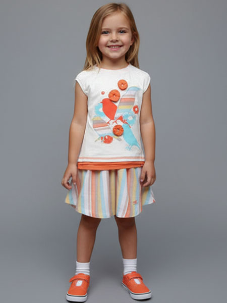Young girl wearing a colorful  skirt and top with a plain background