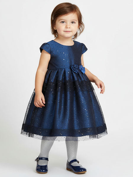 Child wearing a blue dress with a floral detail on a white background