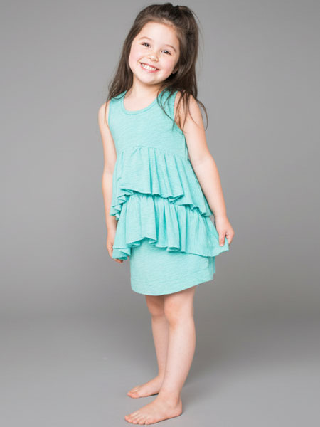 Young girl wearing a light blue dress against a gray background