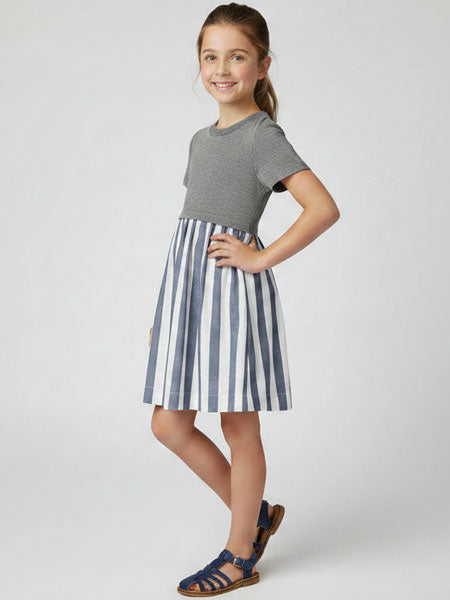 Girl wearing a gray top and striped skirt dress on a white background