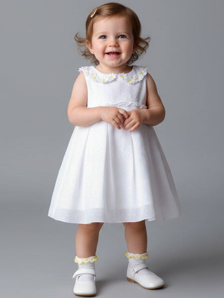 Young girl wearing a white dress with yellow accents on a gray background