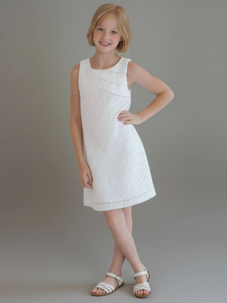 Young girl wearing a white dress against a plain background