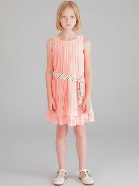 Young girl wearing a pink dress with a belt on a gray background