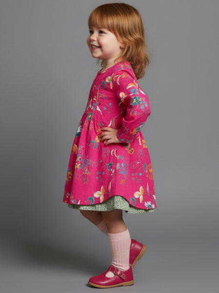 Child wearing a pink floral dress on a gray background