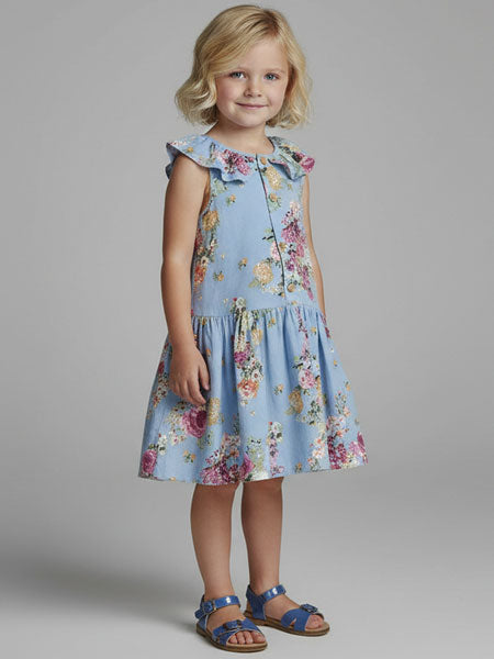 Young girl wearing a floral dress against a plain background