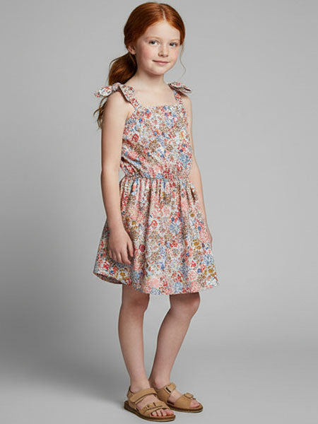 Young girl wearing a floral dress on a gray background