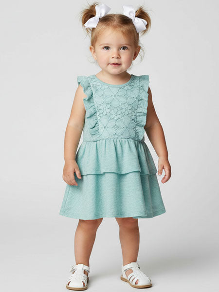 Child wearing a light blue dress with ruffled details on a white background