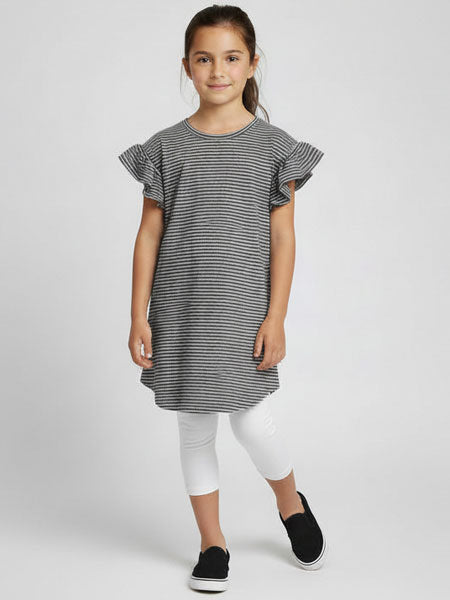 Young girl wearing a black and white striped dress with ruffled sleeves on a white background