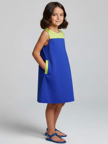 Young girl wearing a blue and green dress on a gray background