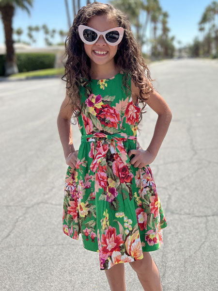 Girls sleeveless dress in a fun green floral print - this dress with petticoats is belted at the waist for a flattering look. Spring and summer party dress.