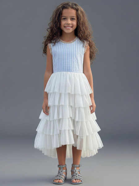 Young girl wearing a light blue top and white tiered dress against a gray background