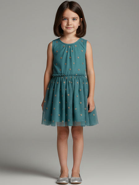 Young girl wearing a teal dress with a subtle pattern on a gray background